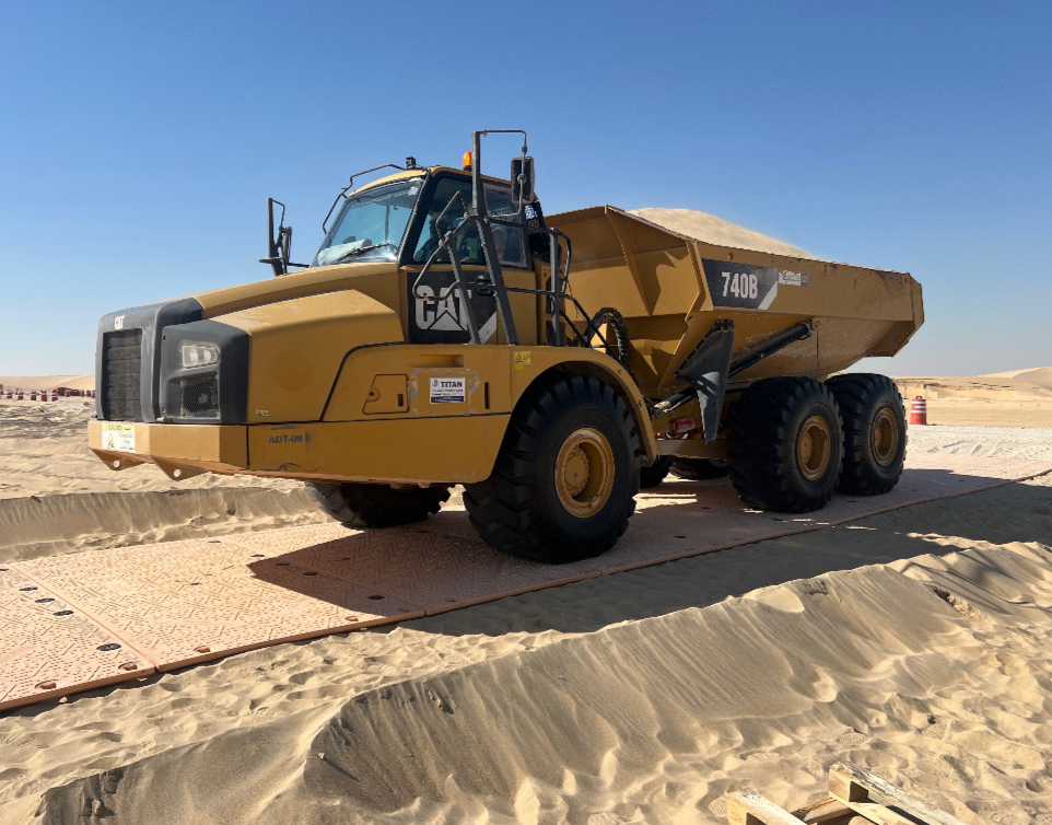 CAT 740B articulated dump truck on temporary access matting in the desert